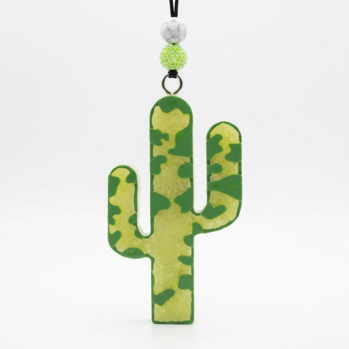 A cactus-shaped keychain or bag charm with a green and yellow camouflage pattern, hanging from a black cord with decorative beads on a white background.
